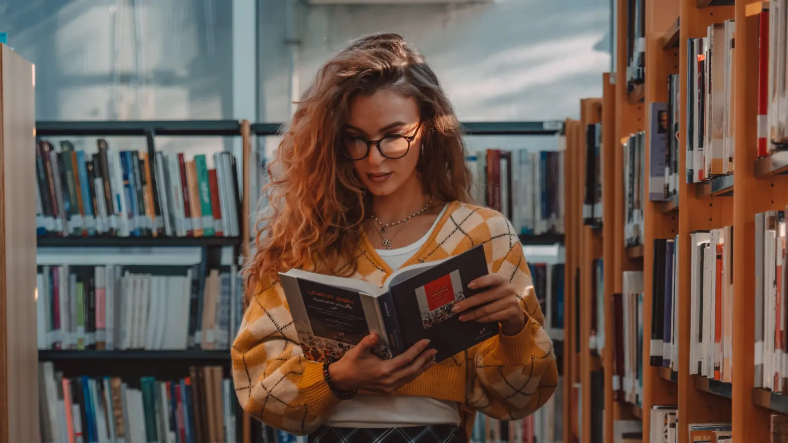 Teen girl wearing glasses showing blank sketchbook. Education